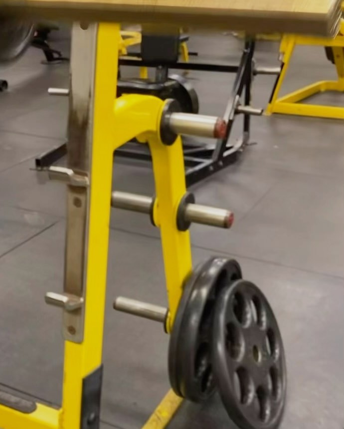 Yellow plate-loaded machine with plates at Fit Nation Norwalk